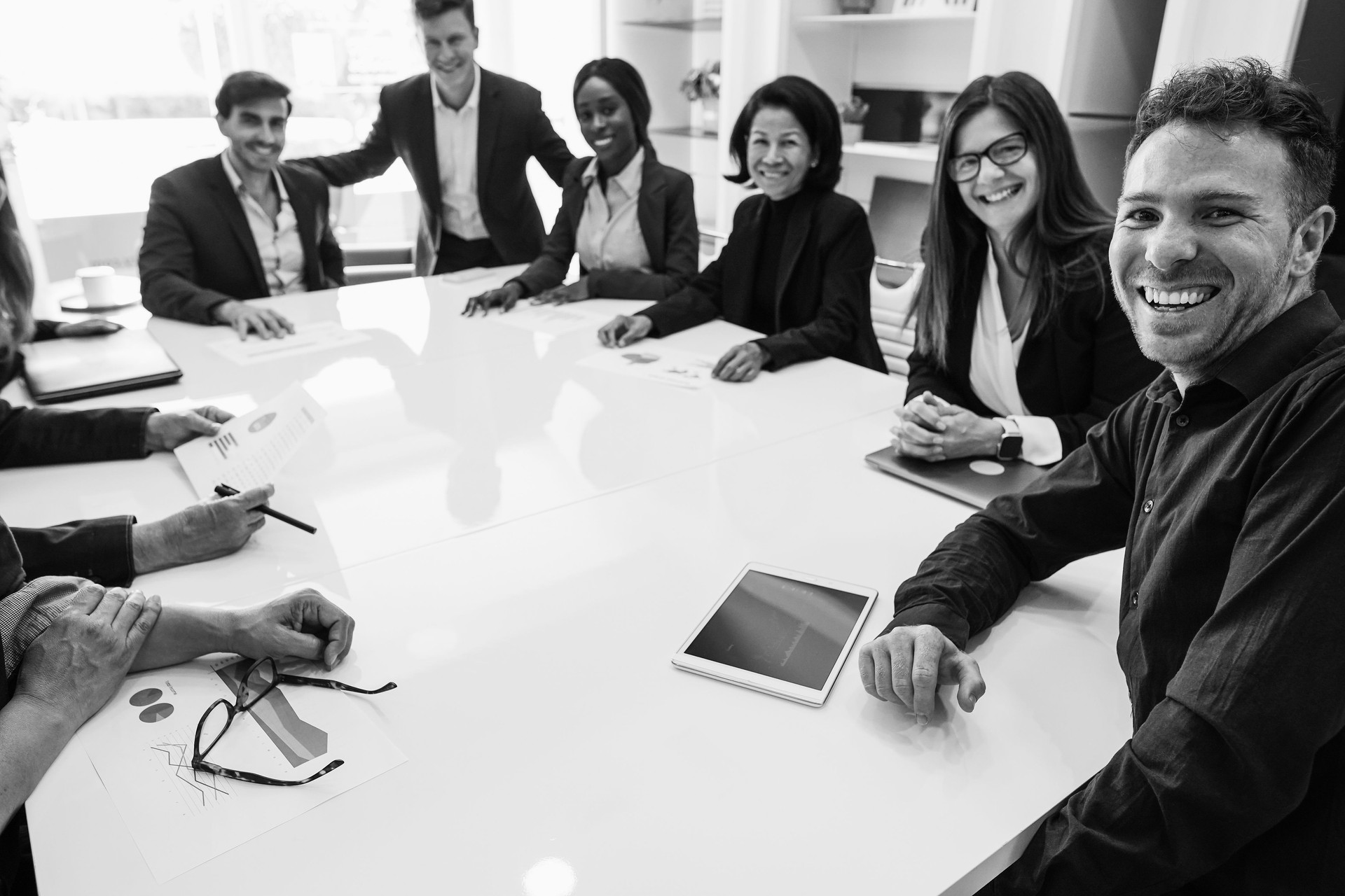 Business people sharing ideas at teamwork meeting - Multiracial colleagues discussing new startup project - Brainstorming and corporate concept - Main focus on right man face - Black and white editing
